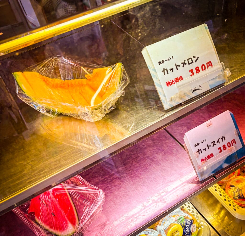 服部農園の売店に並ぶカットメロンとカットスイカ Cut melon and watermelon slices on display at Hattori Garden’s counter