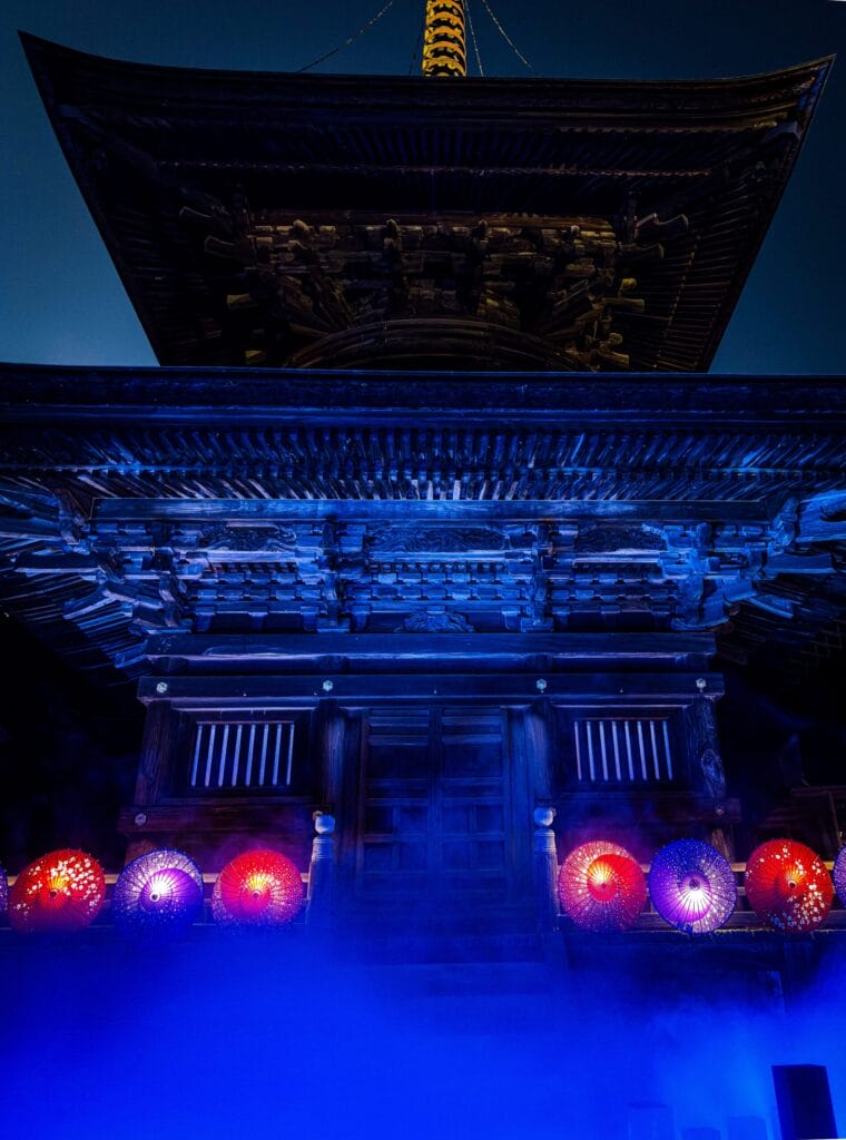 三重塔と和傘が青い光に包まれる夜のライトアップ Three-story pagoda and Japanese umbrellas in blue night light