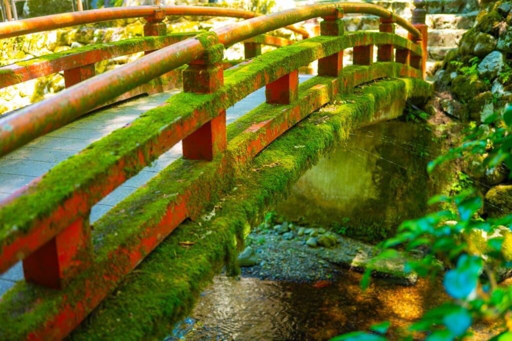 永平寺の小川にかかる苔むした赤い橋。 